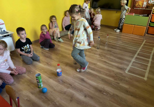 dzieci pokonują butelkowy tor przeszkód