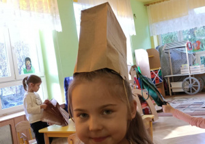 Dziewczynka w czapce wykonanej z papierowej torebki