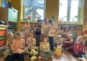 grupa dzieci pozuje do zdjęcia z pracami wykonanymi z recyklingu