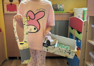 dziewczynki prezentują swoje prace z recyklingu