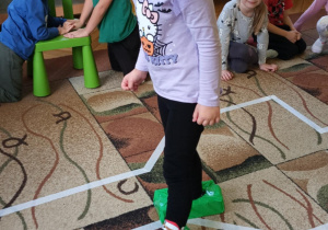 Dziewczynka idzie w butach wykonanych z recyklingu- pudełko po chusteczkach