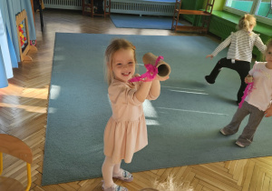 Dziewczynka prezentuje lornetkę z rolki i bibuły.
