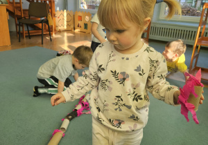 Dziewczynka idzie po sznurku leżącym na dywanie