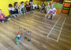 dzieci bawią się w „butelkowe kręgle”