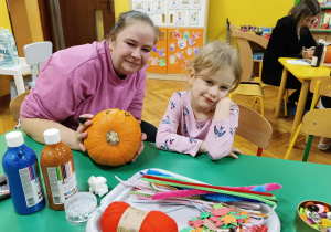 dzieci wraz z rodzicami ozdabiają dynie