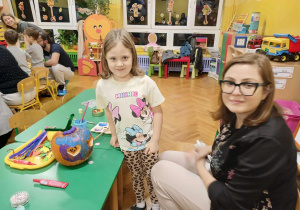 dzieci wraz z rodzicami ozdabiają dynie