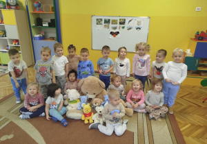 Dzieci z grupy pomarańczowej pozują do zdjęcia z misiami
