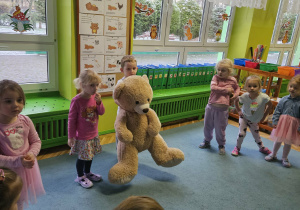 Chłopiec trzyma dużą maskotkę misia.