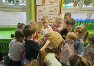 Dzieci przytulają misia
