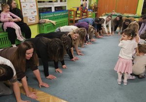 Rodzice tworzą tunel a dzieci przechodzą pod nimi.