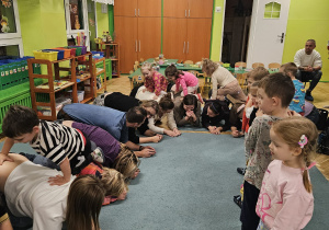 Rodzice tworzą ,,wiadukt" a dzieci przechodzą po nich górą.