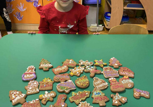 Dziewczyna siedzi przy stoliku z piernikami