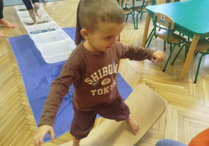 Chłopiec buja się na równoważni