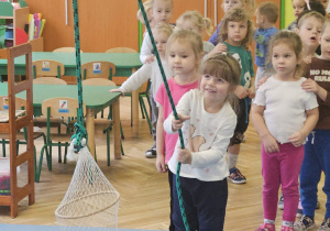 dzieci wyciągają sieć z rybami przeciągając linę.
