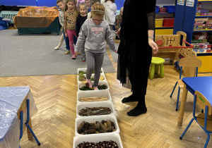 dzieci przechodzą po ścieżce sensorycznej z tworzywa przyrodniczego