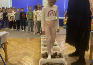 dzieci przechodzą po ścieżce sensorycznej z tworzywa przyrodniczego