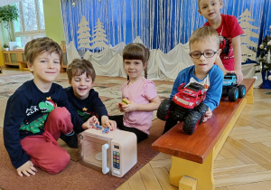 dzieci pozują do zdjęcia z prezentami od Świętego Mikołaja