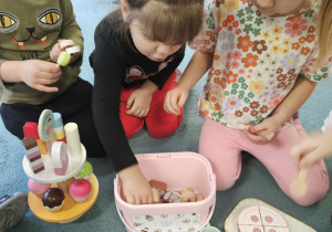 dzieci pozują do zdjęcia z prezentami od Świętego Mikołaja