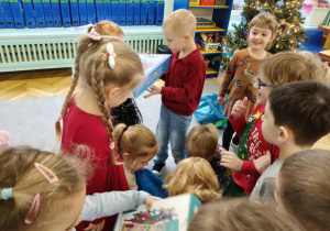 dzieci rozpakowują prezenty od Świętego Mikołaja