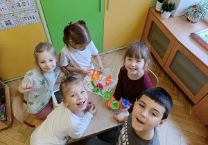 dzieci pozują do zdjęcia z prezentami od Świętego Mikołaja