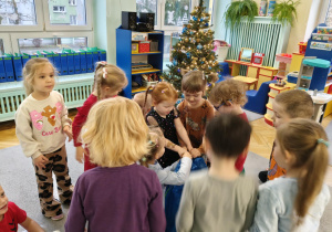 dzieci rozpakowują prezenty od Świętego Mikołaja