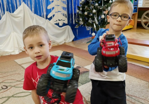 dzieci pozują do zdjęcia z prezentami od Świętego Mikołaja