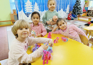 dzieci pozują do zdjęcia z prezentami od Świętego Mikołaja