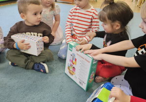 dzieci pozują do zdjęcia z prezentami od Świętego Mikołaja