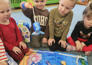 dzieci pozują do zdjęcia z prezentami od Świętego Mikołaja