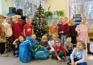 dzieci pozują do zdjęcia z prezentami od Świętego Mikołaja