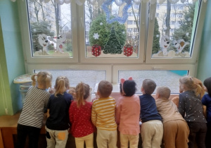 dzieci wypatrują przez okno Świętego Mikołaja
