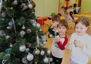 dzieci ubierają choinkę