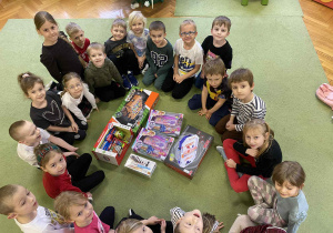 dzieci pozują do zdjęcia z prezentami od Świętego Mikołaja