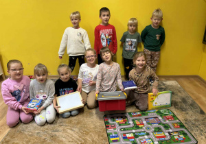 dzieci pozują do zdjęcia z prezentami od Świętego Mikołaja