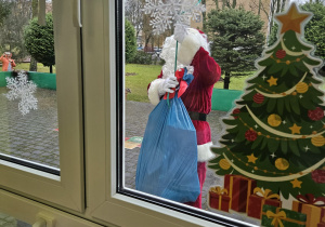 Mikołaj wręczający worki z prezentami dla dzieci