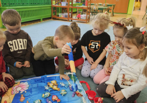 dzieci pozują do zdjęcia z prezentami od Świętego Mikołaja