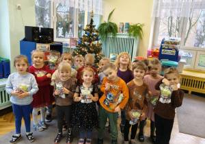 dzieci pozują do zdjęcia z prezentami od Świętego Mikołaja