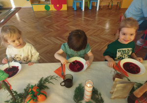 dzieci wspólnie siedzą przy świątecznym stole, spożywają potrawy