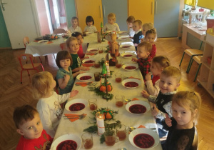 dzieci wspólnie siedzą przy świątecznym stole, spożywają potrawy