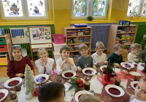dzieci wspólnie siedzą przy świątecznym stole, spożywają potrawy