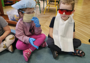 Dzieci w maseczkach, rękawiczkach szczotkują zęby