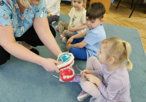 Dzieci segregują artykuły spożywcze zdrowe i nie zdrowe dla zębów.