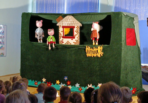 dzieci siedzą w sali oglądając przedstawienie