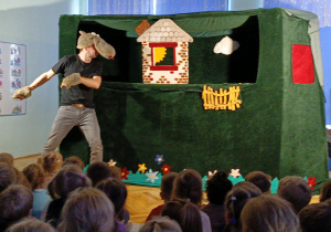 dzieci siedzą w sali oglądając przedstawienie