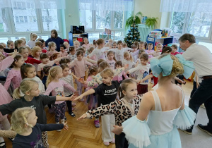 dziewczynki uczą się układu kroków jaki prezentuje baletnica