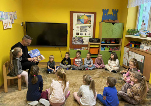 tata Małgosi czyta dzieciom książkę.