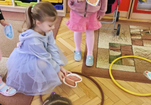 dzieci segregują odpady do kolorowych obręczy