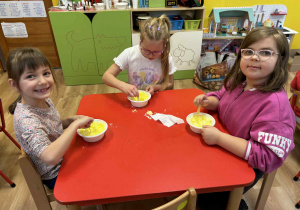 dzieci mieszają w miseczkach patyczkami składniki do wykonania kul do kąpieli,