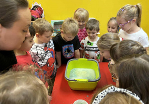 dzieci obserwują zachowanie się kuli do kąpieli w wodzie,