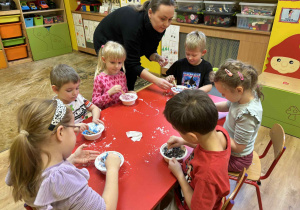 dzieci mieszają w miseczkach patyczkami składniki do wykonania kul do kąpieli,